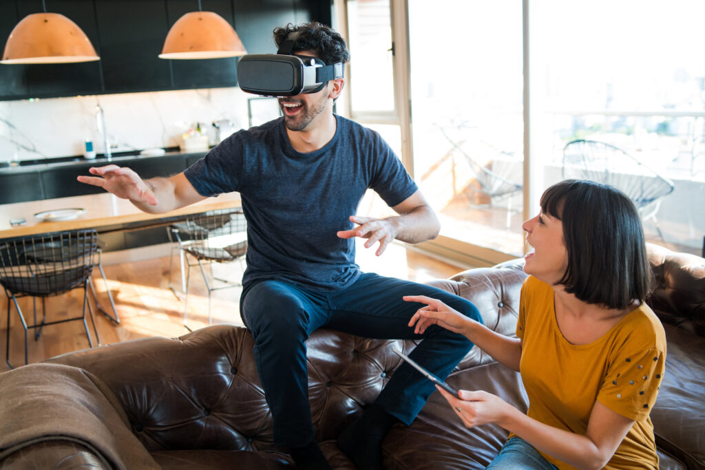 portrait young couple having fun together playing video games with vr glasses while staying home